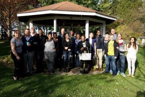 A large group of people standing in front of a gazebo and smiling into the camera.