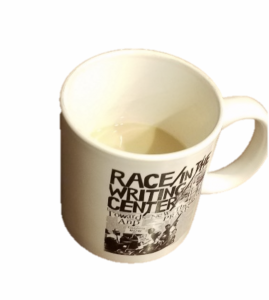 The picture is of a coffee mug with coffee inside. The mug is from a conference on Race and Writing Centers.