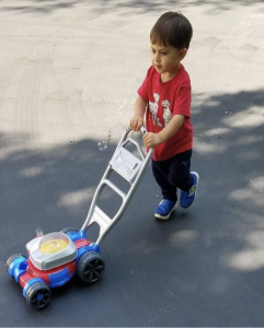The author's youngest son pushes his bubble mower northwest across a driveway.