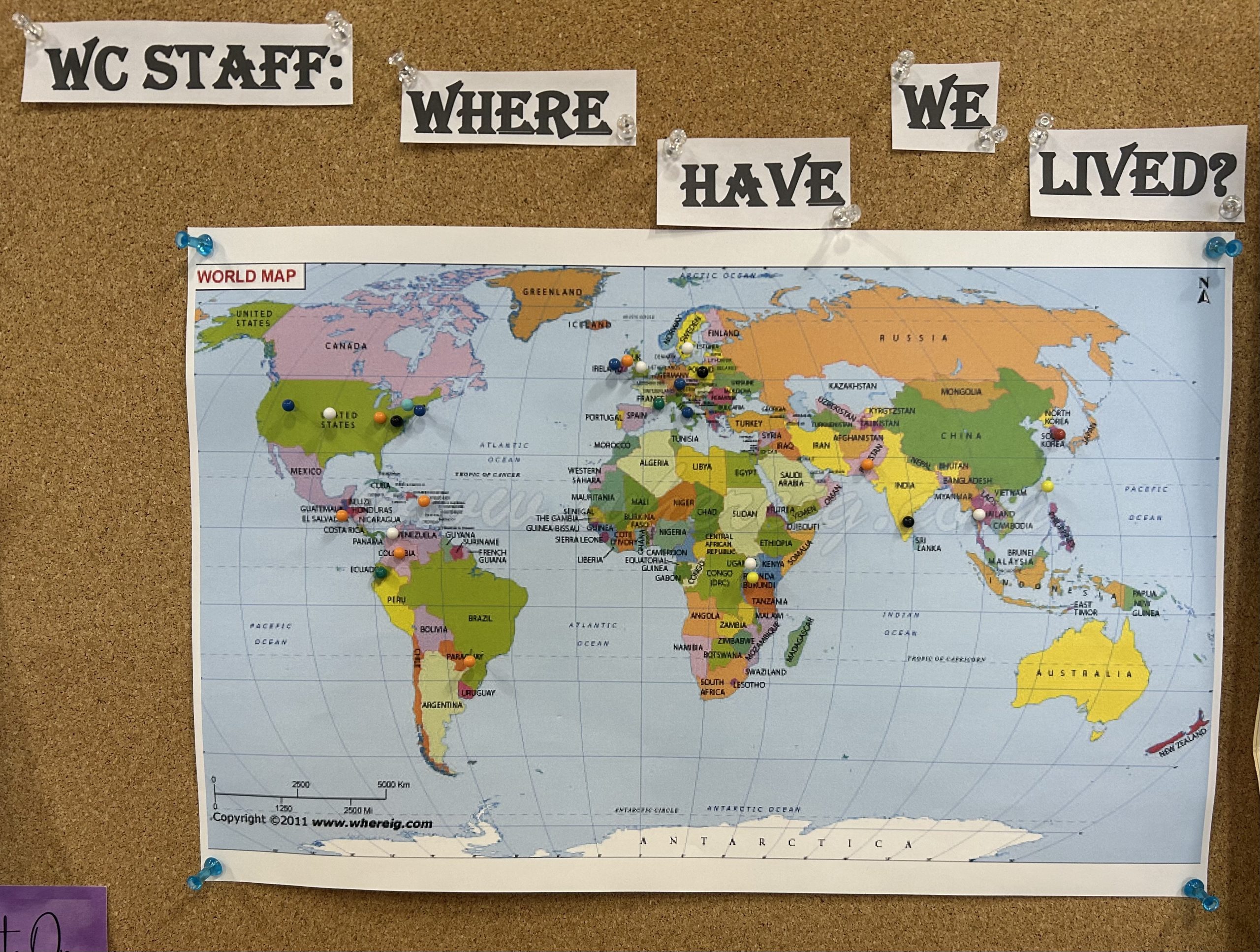 Map of the world with push pins inserted indicating where writing center staff is from/have visited.